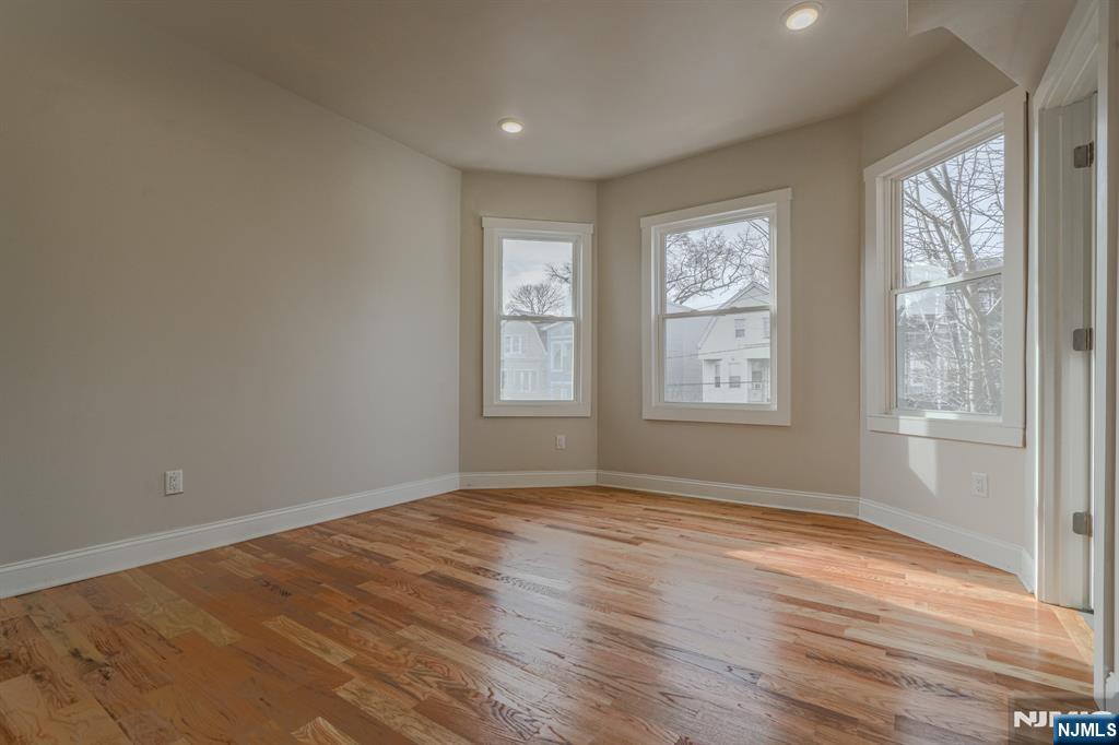 882 South 14th Street, Unit 2 Newark, NJ 07108 - Photo 2 of 18 a view of an empty room with wooden floor and a window