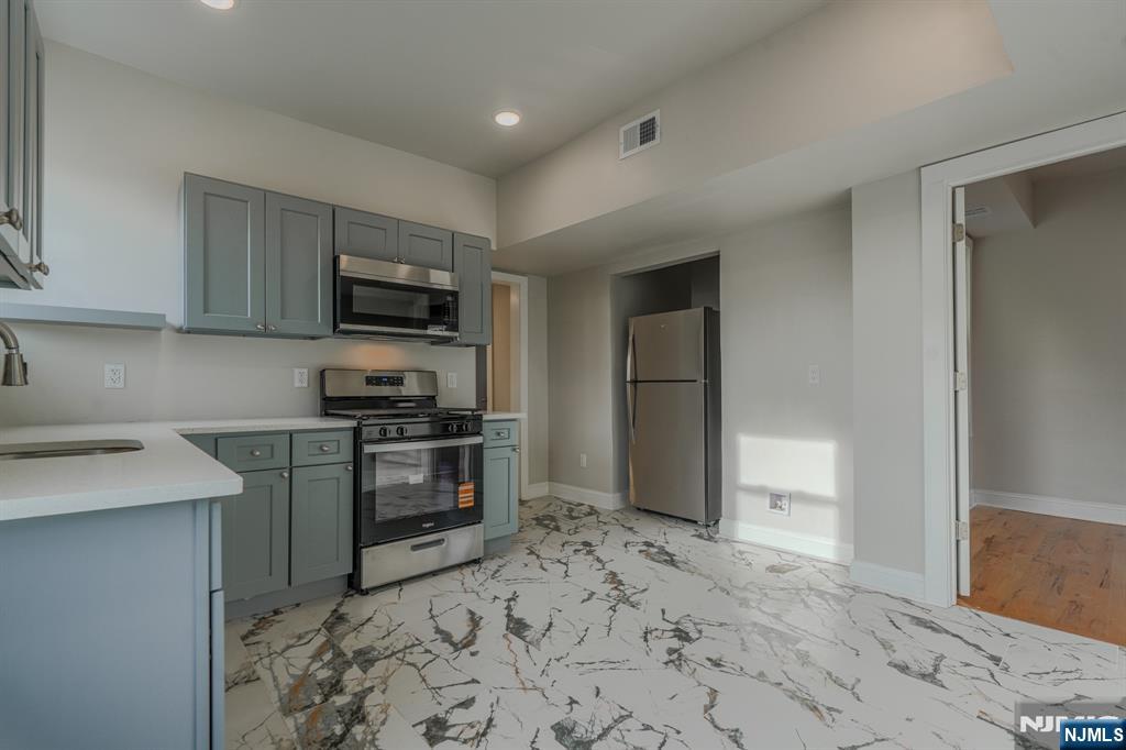882 South 14th Street, Unit 2 Newark, NJ 07108 - Photo 9 of 18 a kitchen with a refrigerator stove and sink