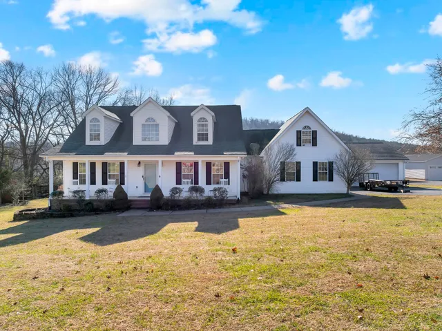 a front view of a house with yard and swimming pool