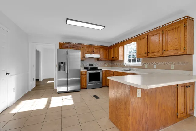 a kitchen with stainless steel appliances granite countertop a stove a sink and a refrigerator