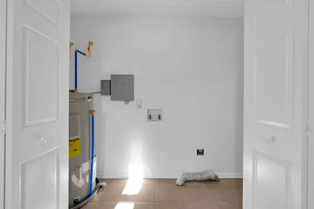 an empty room with chandelier fan and windows