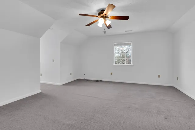an empty room with closet and windows