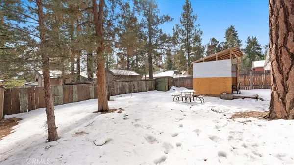 a view of backyard with a table and chairs under a large tree