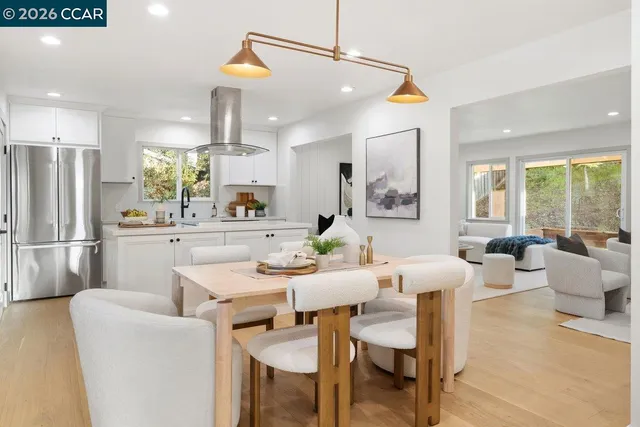 a dining room with furniture a large window and stainless steel appliances