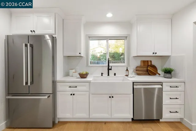 a kitchen with white cabinets and white stainless steel appliances