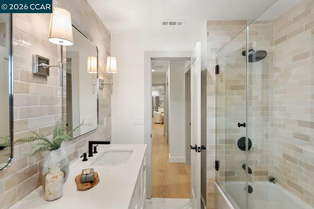 a bathroom with a tub sink and mirror