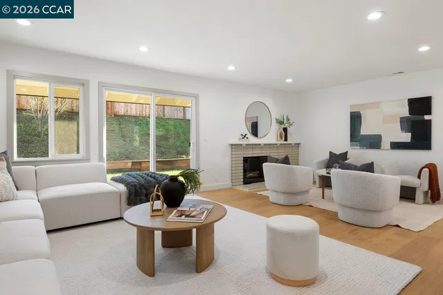 a living room with furniture fireplace and a large window