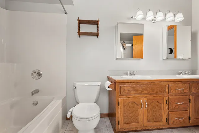 a bathroom with a sink a toilet a mirror and bathtub