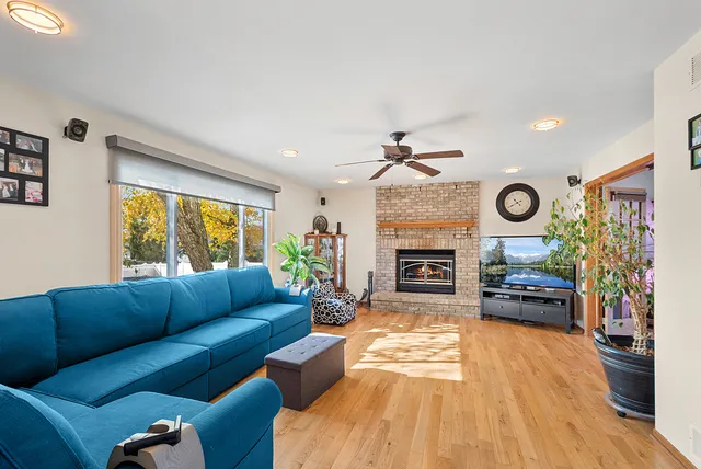 a living room with furniture a fireplace and a floor to ceiling window