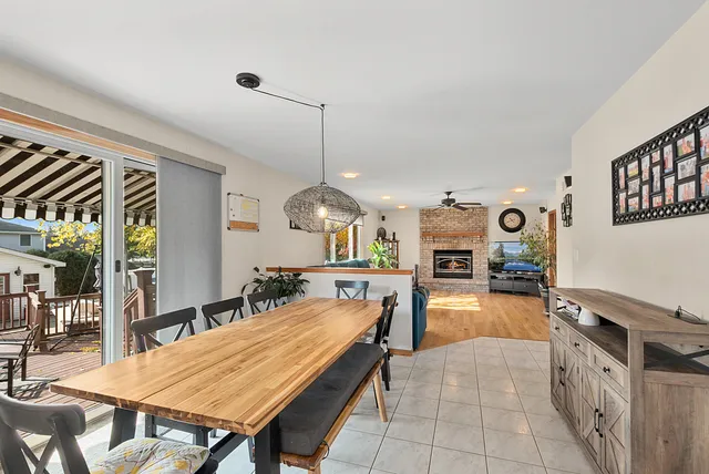 a open kitchen with stainless steel appliances granite countertop a stove a refrigerator a oven a dining table and chairs with wooden floor