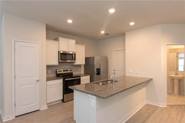 a kitchen with stainless steel appliances granite countertop a sink stove and refrigerator