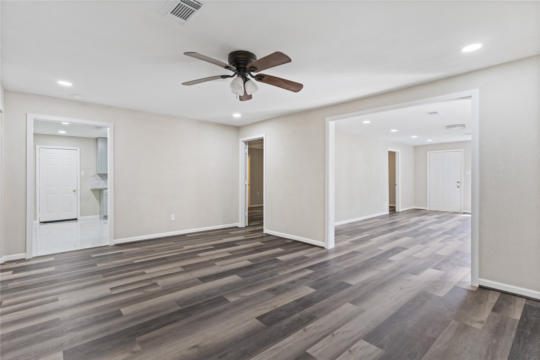 10613 Chadwick Street Houston, TX 77029 - Photo 11 of 30 a view of an empty room with wooden floor and a ceiling fan