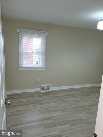 a view of a room with wooden floor and window