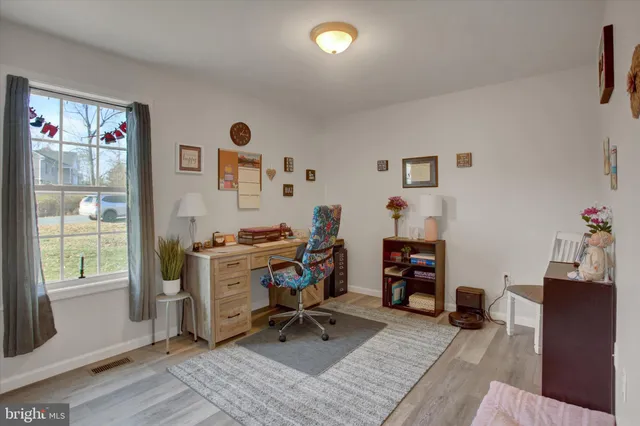 a view of a workspace with furniture and a window