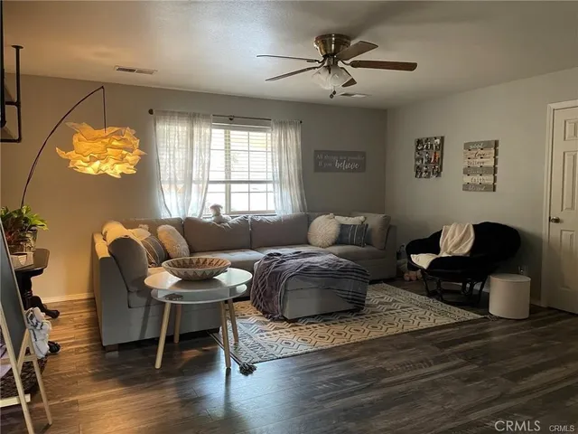 a living room with furniture a chandelier and a window