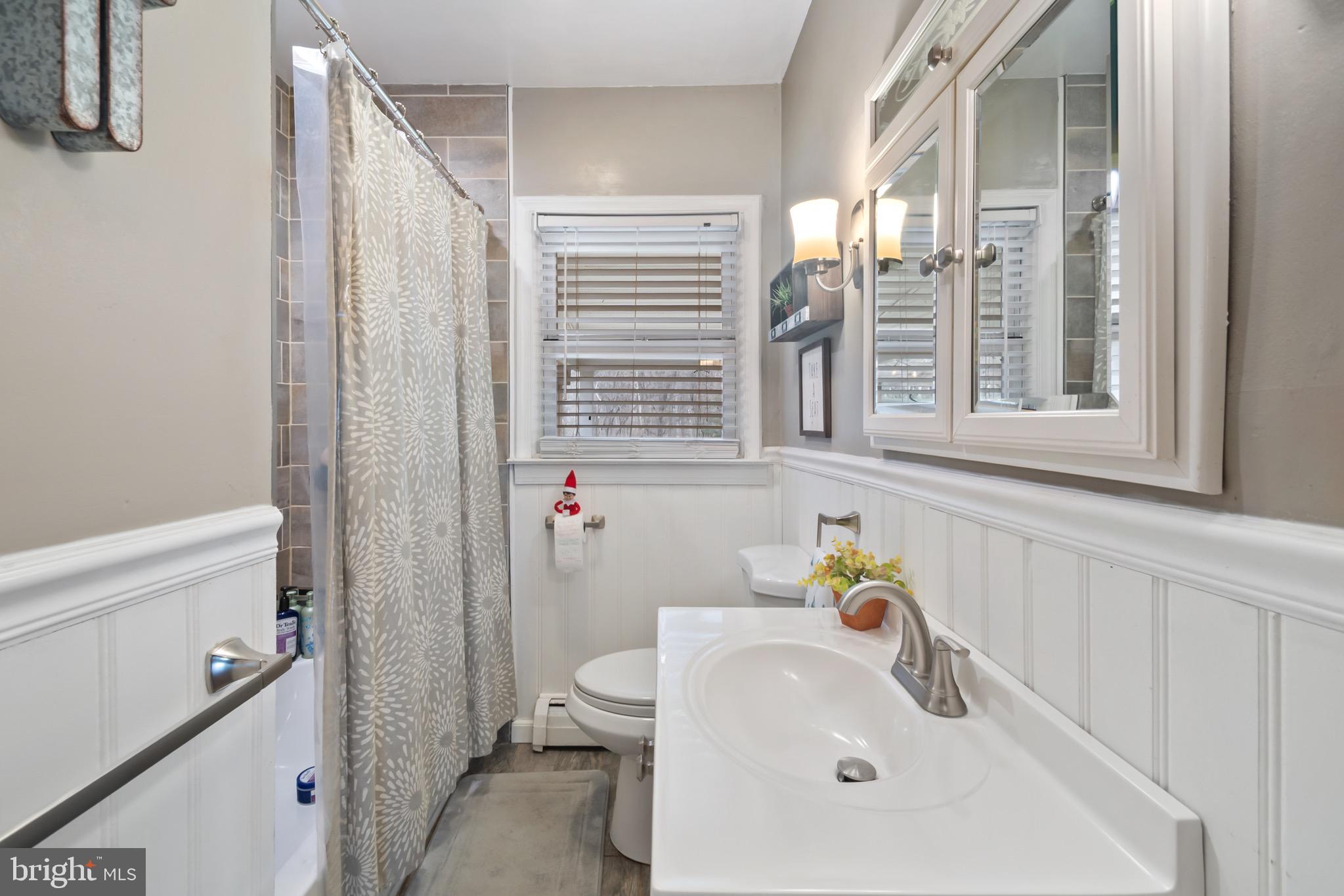 10520 Scaggsville Road Laurel, MD 20723 - Photo 18 of 32 a bathroom with a sink a toilet and shower curtain