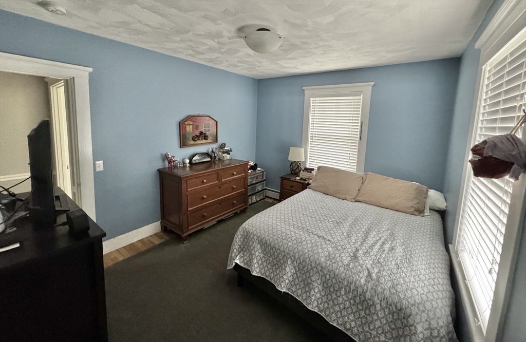 16 Evans Road Needham, MA 02492 - Photo 14 of 23 a bedroom with a bed and a chandelier