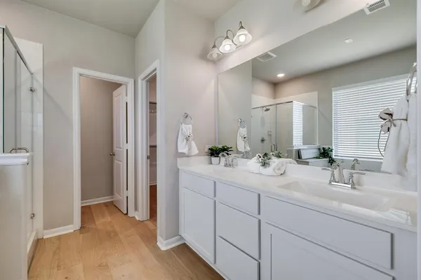a bathroom with a double vanity sink mirror and shower