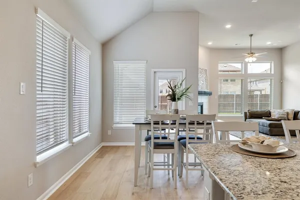a dining room with furniture large window and wooden floor