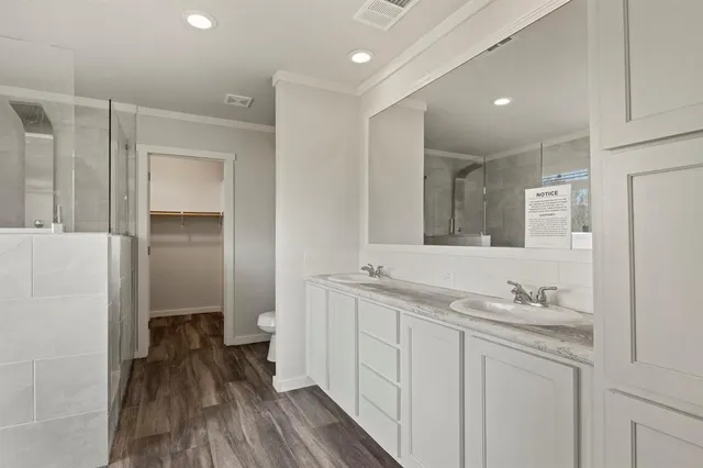 a bathroom with a sink a toilet and a large mirror