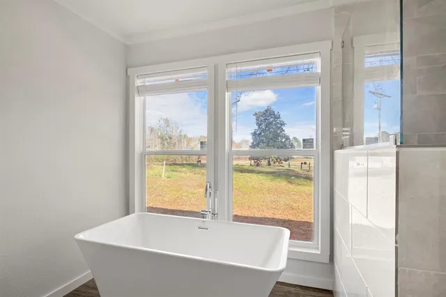 a white bath tub sitting in a bathroom next to a window