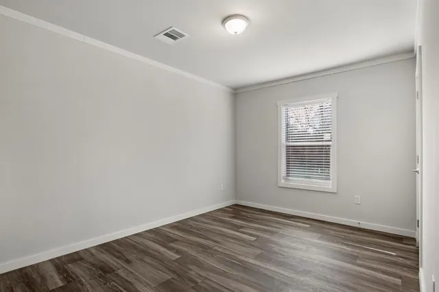 a view of a room with wooden floor and a window