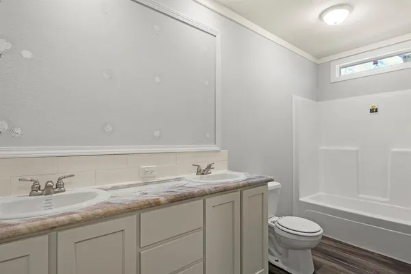 a bathroom with a granite countertop sink and a toilet