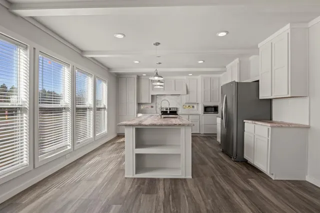a kitchen with a refrigerator a sink and cabinets