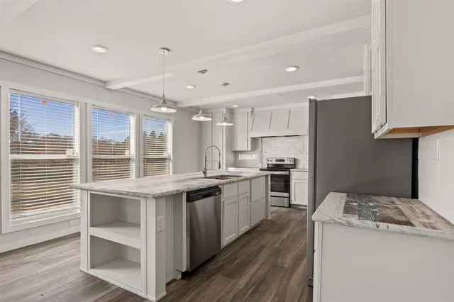 a kitchen with a stove a sink and a refrigerator