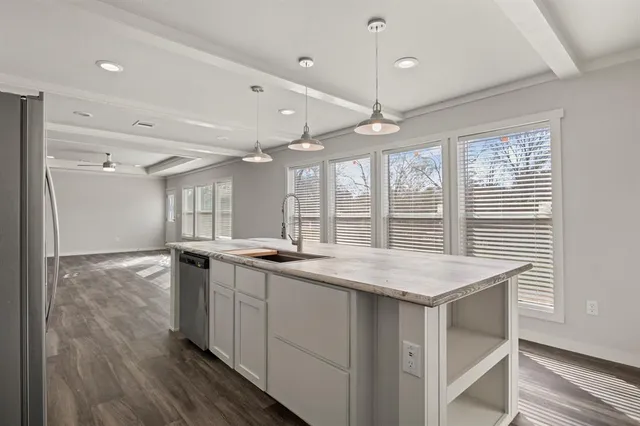 a kitchen with stainless steel appliances granite countertop a stove and a wooden floors