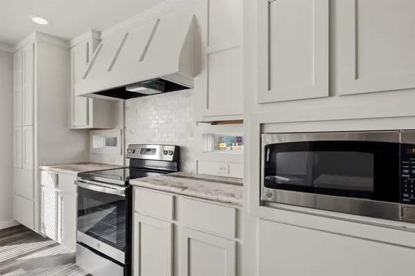 a kitchen with stainless steel appliances white cabinets and a stove a oven with white countertops