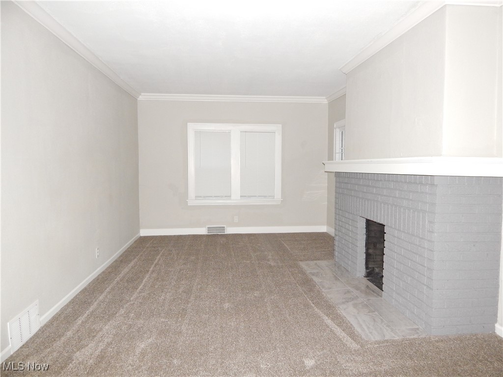 3845 Summit Park Road Cleveland Heights, OH 44121 - Photo 4 of 15 living room with a brick fireplace, visible vents, and crown molding