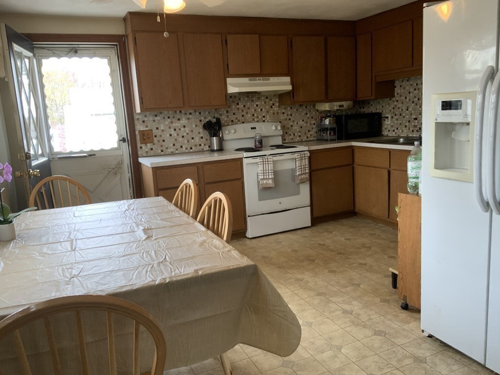 44-46 Catalina Road Lynn, MA 01905 - Photo 22 of 28 a kitchen with stainless steel appliances kitchen island granite countertop a sink a stove and a refrigerator