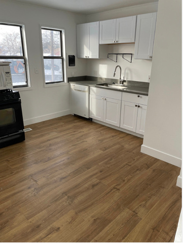 230 North 2nd Street Tooele, UT 84074 - Photo 2 of 18 Kitchen with wood-finish flooring, white cabinetry, dark countertops, and stainless steel sink with a gooseneck faucet