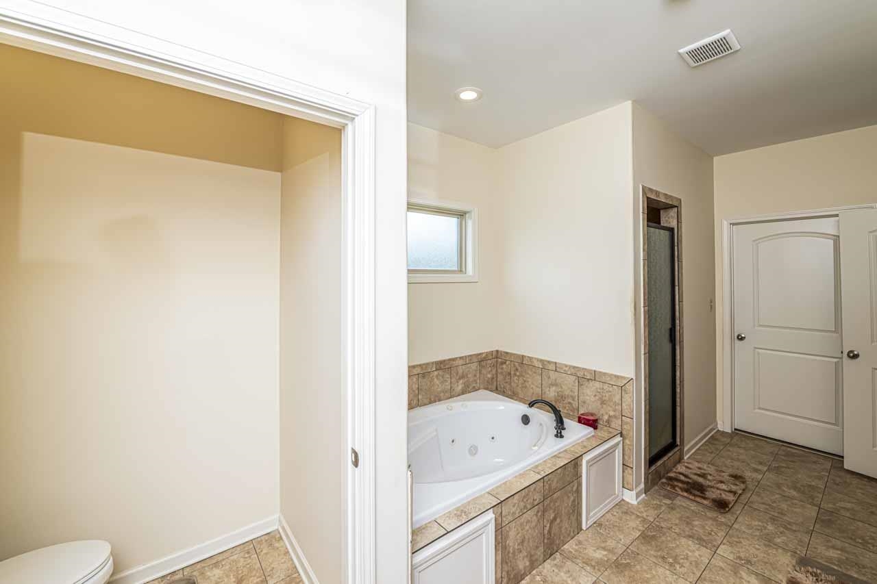 185 Belmont Road Mason, TN 38049 - Photo 13 of 38 Soaking tub with tiled surround, adjacent to a separate shower enclosure