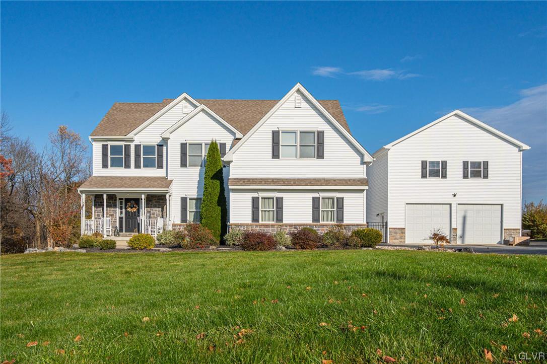 a front view of a house with a yard and trees