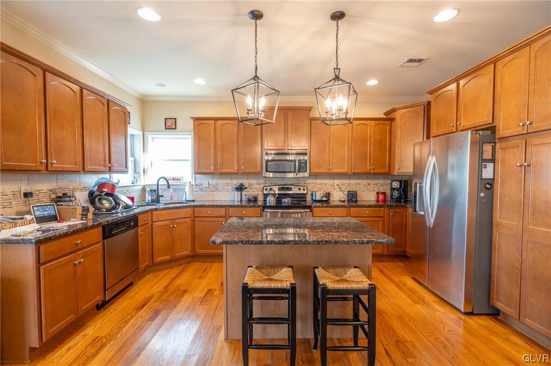 1240 Miller Road Wind Gap, PA 18091 - Photo 16 of 48 a kitchen with stainless steel appliances granite countertop a refrigerator a sink dishwasher a stove and white cabinets with wooden floor