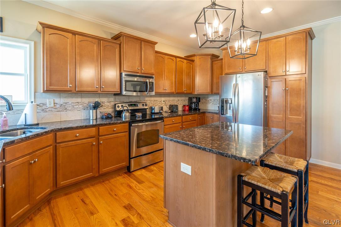 1240 Miller Road Wind Gap, PA 18091 - Photo 17 of 48 a kitchen with stainless steel appliances granite countertop a refrigerator a stove a sink a dining table and chairs with wooden floor