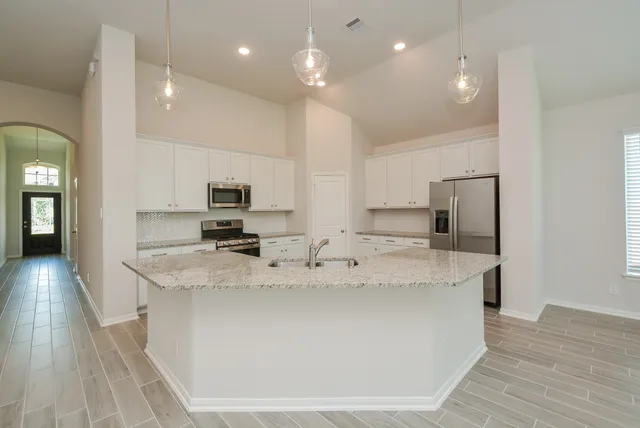 a large kitchen with kitchen island a sink stainless steel appliances and cabinets