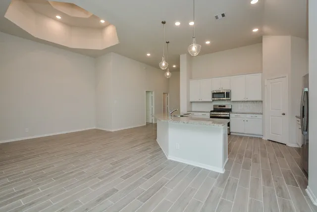 a view of kitchen with stainless steel appliances cabinets and wooden floor