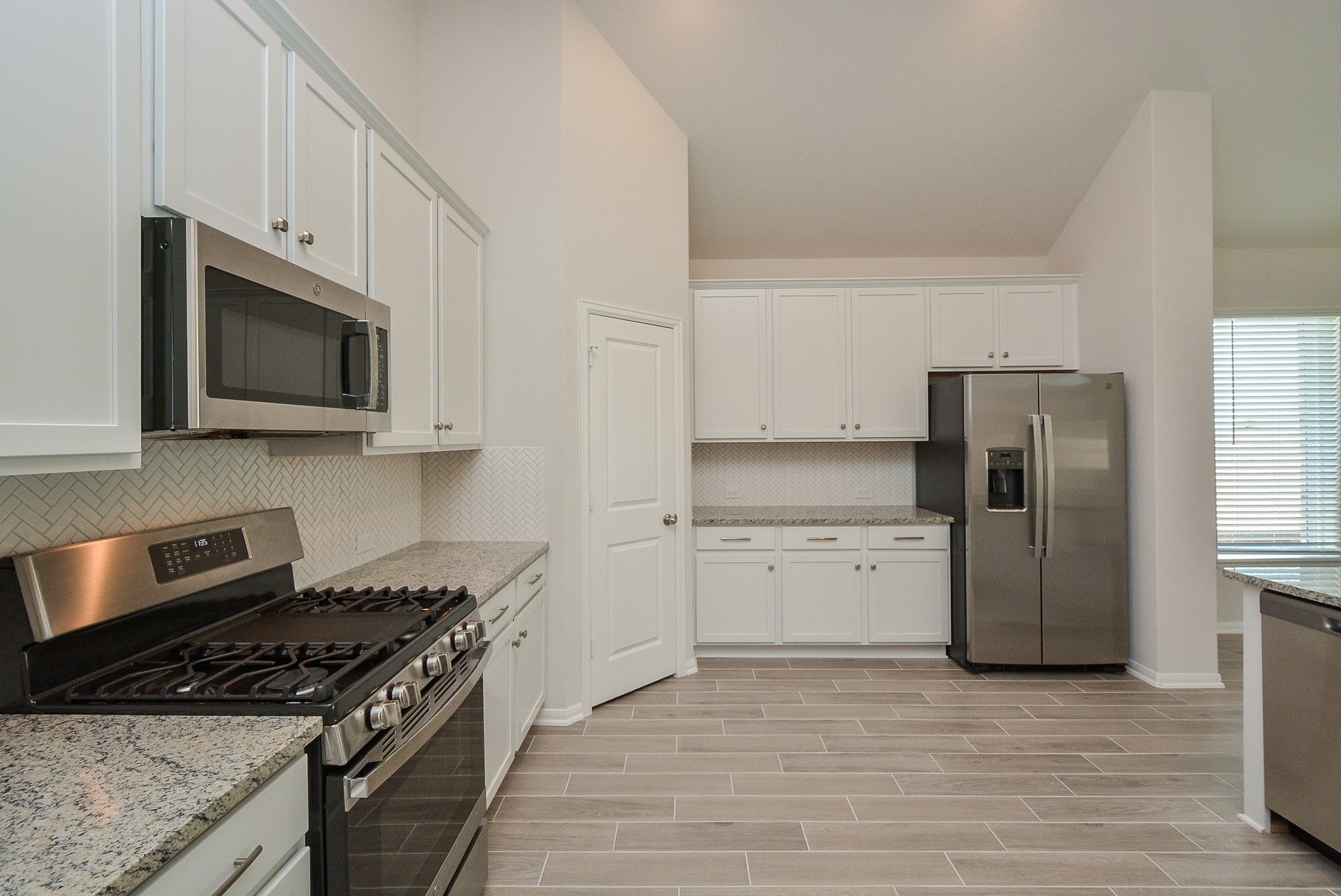 8634 Herring Lane Cypress, TX 77433 - Photo 26 of 50 a kitchen with a stove microwave and refrigerator