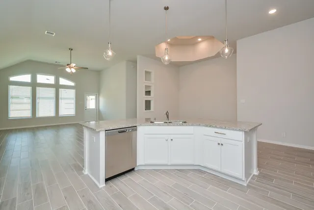 a large white kitchen with a large window a sink and stainless steel appliances
