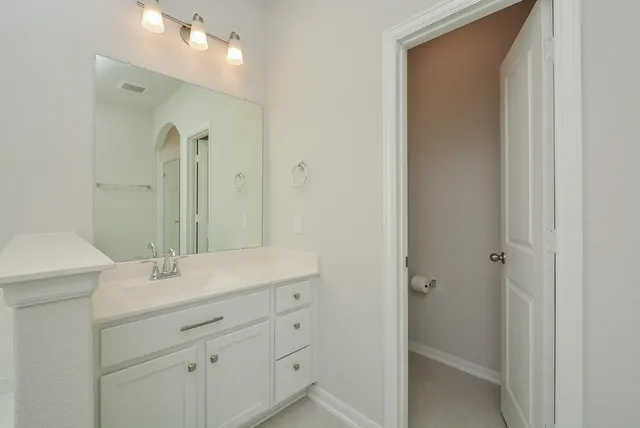 a spacious bathroom with a mirror a shower and vanity
