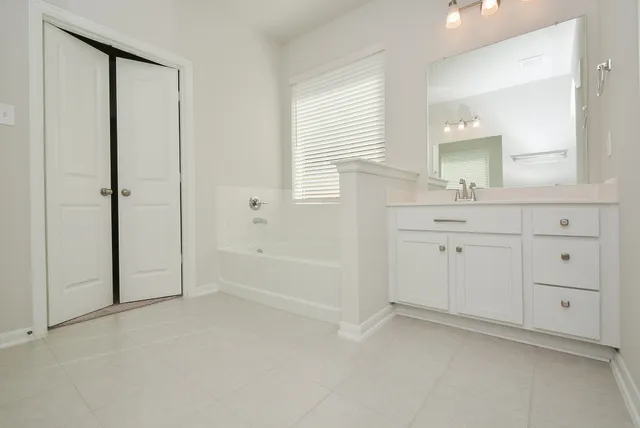 a spacious bathroom with a tub shower and sink