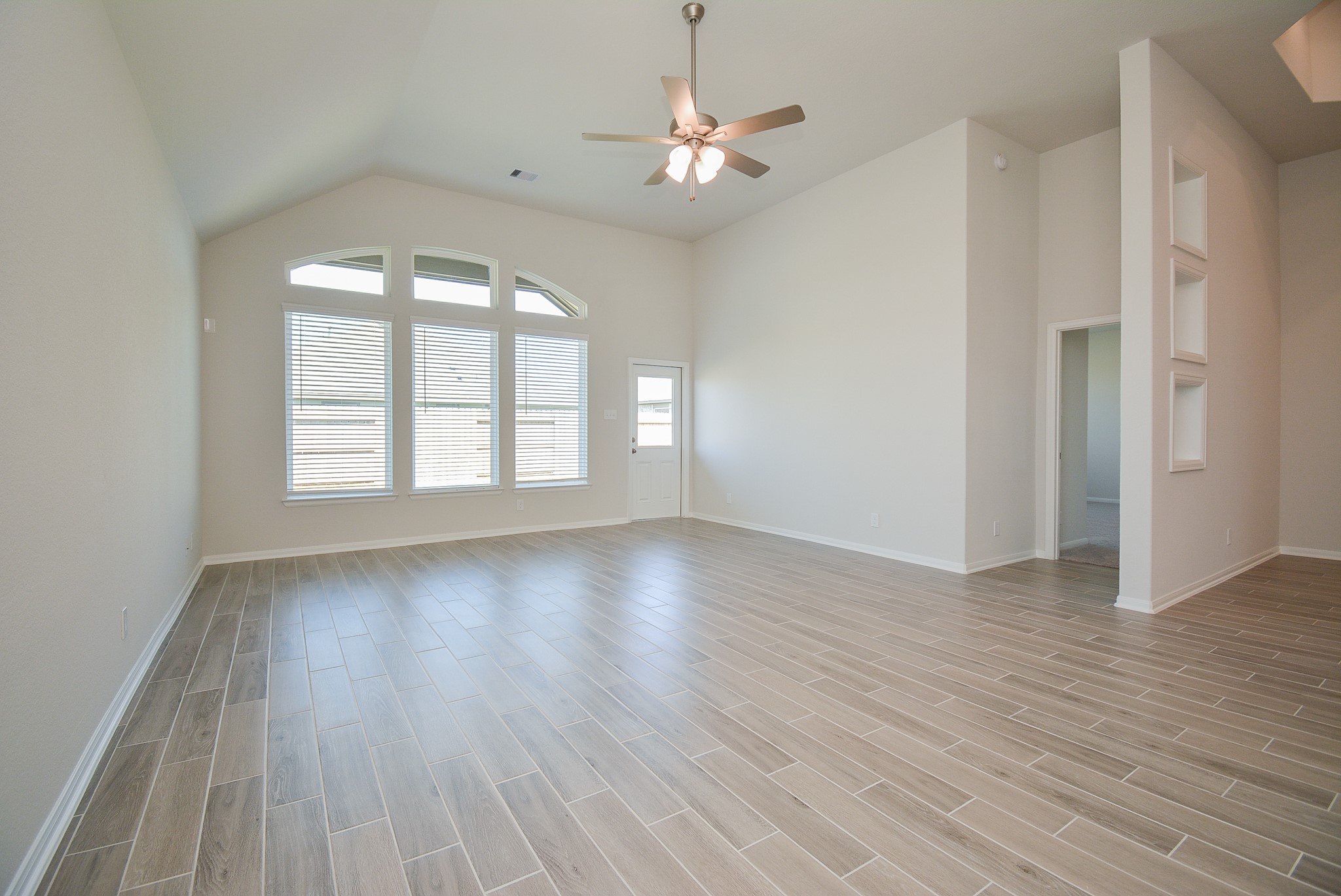 8634 Herring Lane Cypress, TX 77433 - Photo 6 of 50 an empty room with wooden floor chandelier fan and windows