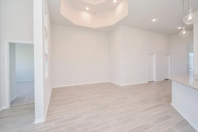 a view of an empty room with wooden floor and closet