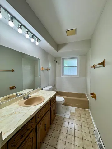 a bathroom with a sink a toilet a mirror and shower