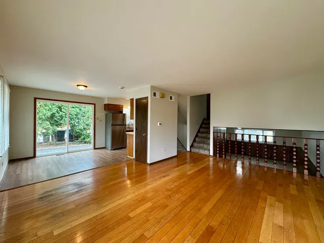 a view of empty room with wooden floor and floor to ceiling window