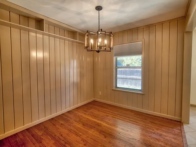 a view of a chandelier in big room with wooden floor chandeliers