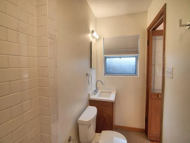 a bathroom with a toilet sink and mirror